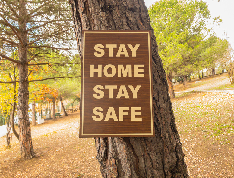 Stay home stay safe sign on a tree